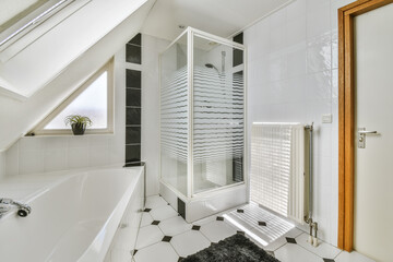 a white bathroom with black and white tiles on the floor, there is a freestanding shower stall in the corner