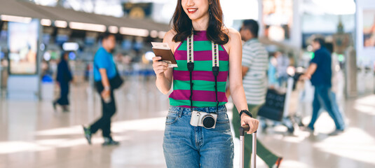 Tourist woman passenger at international airport terminal for holidays travel hand holding passport and boarding pass