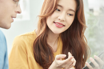 Multinational Man and Woman Discussing Indoors with Smartphone