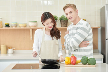 Caucasian Man and Asian Woman Cooking Together in Modern Kitchen