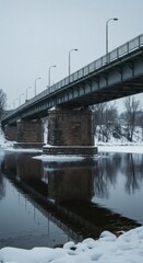 Fototapeta premium Winter Bridge: Steel Structure Reflecting on Calm, Snowy River