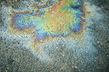 Colorful Oil Slick on Pavement Reflecting Light in Vibrant Patterns During Daytime.
