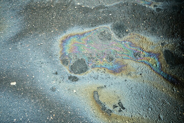 Oil Spill on Asphalt Creates Colorful Rainbow Pattern Under Natural Light During the Day.