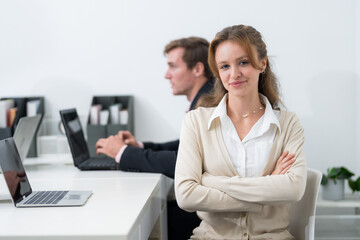 Professional workspace featuring a confident woman and a focused man engaged in productive tasks during office hours