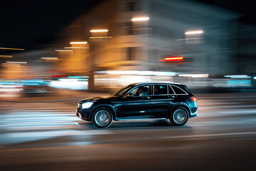 Motion blur shot of a car driving in the night trough town