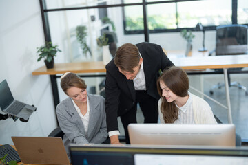 Fototapeta premium Business team collaborates on project in modern office setting during daytime hours