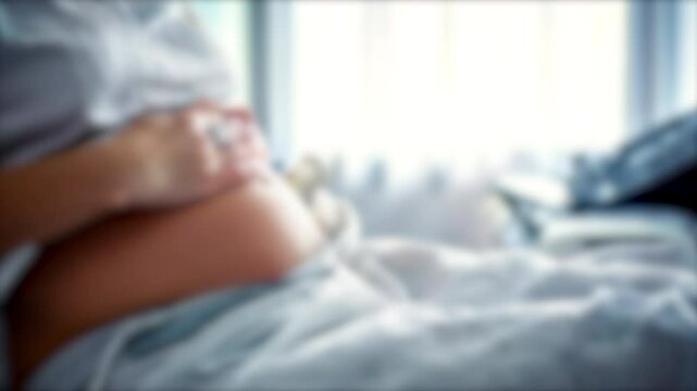 Defocus Background: Closeup of Pregnant Woman Relaxing and Stroking Her Belly in Hospital.