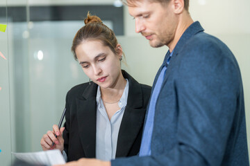 Business professionals collaborate on project review in modern office setting during daytime