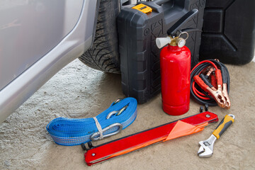 Accessories for operating a car on the garage floor. Warning triangle, tow rope, work tools, fire...