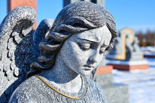 A hauntingly beautiful black marble statue of a sorrowful angel with broken wings