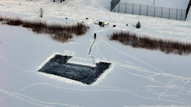Man Clearing The Snow In A Field In Pinki, Latvia - Aerial Shot