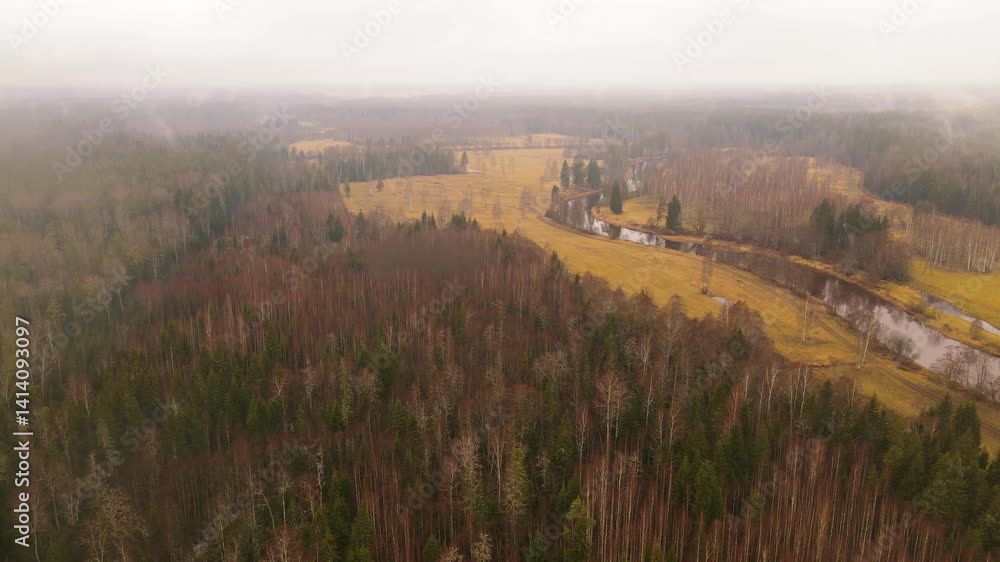Poster aerial view of a winding river through autumn fields and forests under an overcast sky, with visible
