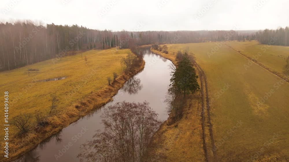 Poster aerial view of a winding river through autumn fields and forests under an overcast sky, with visible