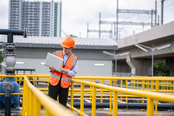 Fototapeta premium Engineer take water from wastewater treatment pond to check the quality of the water after going through program wastewater treatment process in industry environment concept.