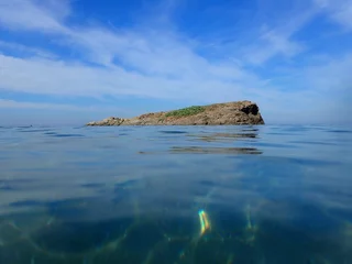 Island in the Mediterranean Sea, sea with clear blue water on a sunny day with beautiful sky and clouds, summer background concept, holiday on beach coast and swimming in Jijel Algeria, Africa.
