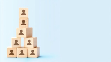Fototapeta premium Wooden cubes with human icons arranged in a pyramid on a blue background, symbolizing business hierarchy and team selection.