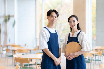 Obraz premium カフェで働く若い男女の店員