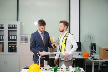 Architects and designers collaborate on urban plans, models and green solutions. A modern office...