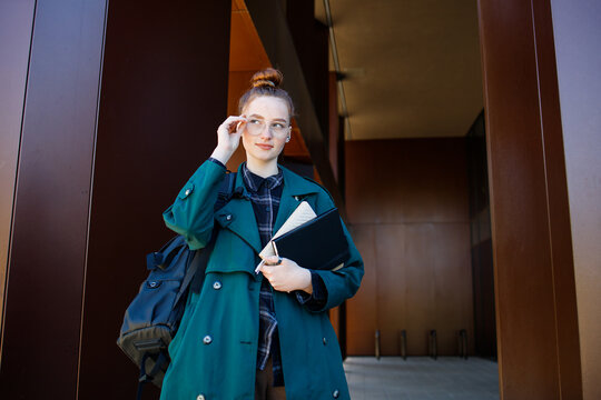 Student ginger girl at modern university campus building