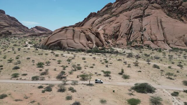 Scenic view of Spitzkoppe peaks and deserted field under a blue sunny sky in Namibia