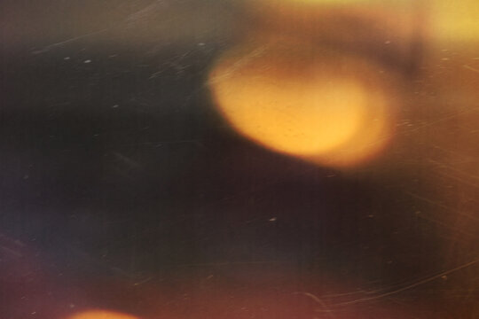 grainy colorful warm orange light leaks on black background with dust texture. abstract damaged scratched retro film analog effect for using over photos as overlay or screen filter