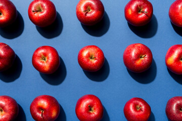 Many red apples on colored background, top view. Autumn pattern with fresh apple above view
