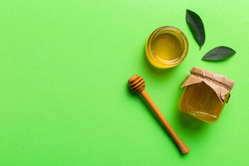 Honey jar with wooden honey dipper on white background top view with copy space. Delicious honey bottle