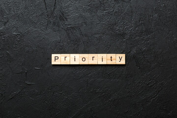 priority word written on wood block. priority text on table, concept