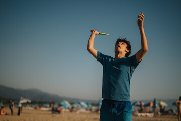 An individual in a blue outfit playing frisbee on a sunny beach, enjoying a fun and active moment...