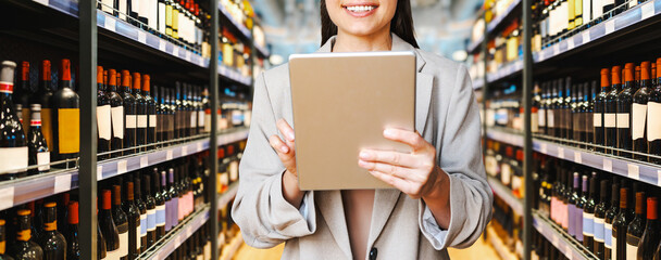Businesswoman using digital tablet in wine and liquor store