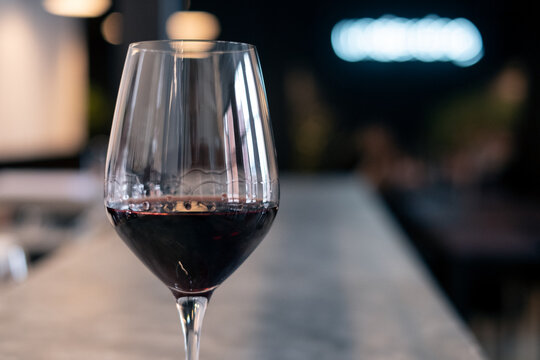 Close-up of a glass of red wine on a bar counter