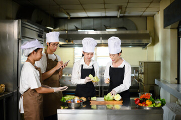 Group of culinary students in chef hats learning food preparation techniques