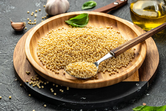 Raw pasta fregola sarda ricette on a dark background. top view. copy space for text