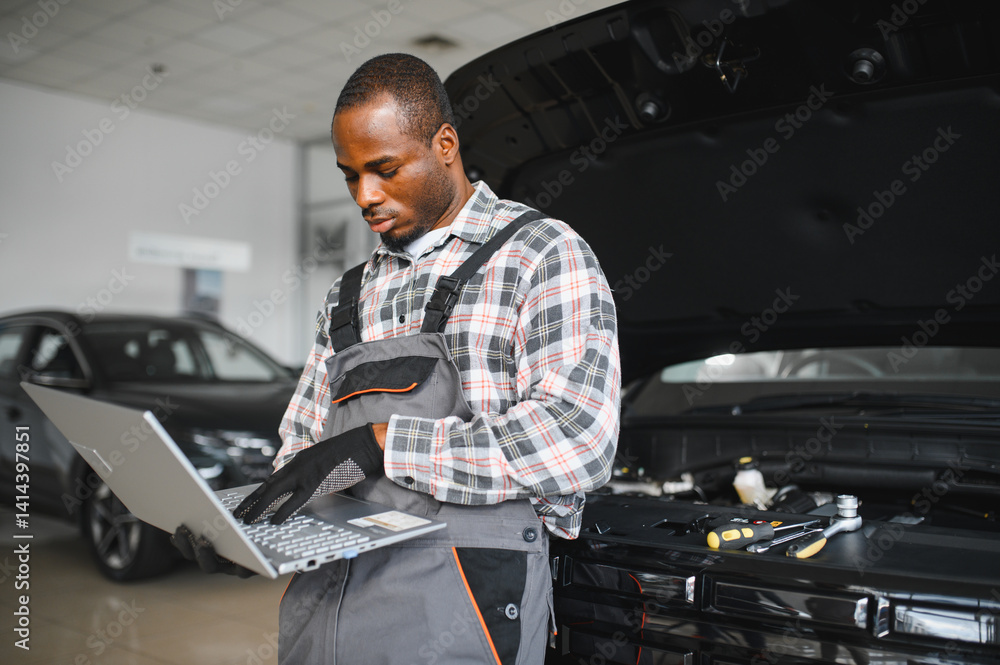 Aufkleber Black auto mechanic running diagnostic on laptop while analyzing engine problems in a workshop
