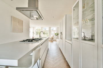 Sleek and stylish kitchen featuring white cabinetry, a gas stove, and large windows allowing ample natural light, creating a bright and airy ambiance.