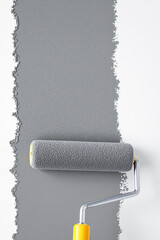 Obraz premium close-up of paint roller applying textured gray paint to white wall