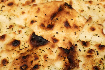 Close up of the surface of a fresh flatbread bread with herbs