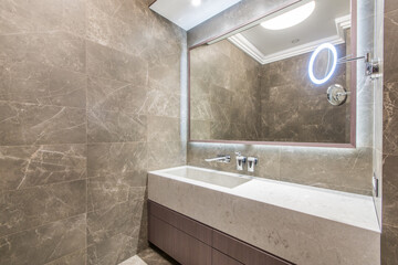Elegant design of the bathroom, decorated with gray marble tiles. Stylish marble countertop with...