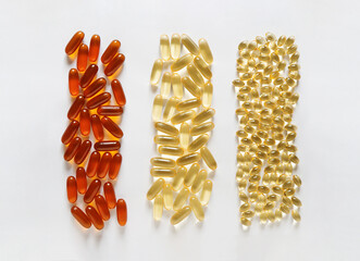 capsules of different sizes and colors of vitamins on the white background, omega 3 fish oil,...