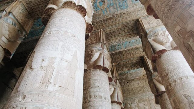 Low angle view of columns and ceiling decorated with reliefs and hieroglyphics at Hypostyle Hall of Temple of Hathor. Dendera Temple complex, Qena, Egypt