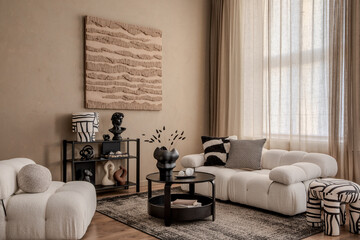Modern living room with sculptural wall art, tufted sofa, black decor accents and warm beige...