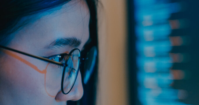 Closeup young Asia female freelance eyeglasses typing write prompt AI bot IT program nomad, video game, terminal with coding language, designer, big data center on desktop computer in night office.