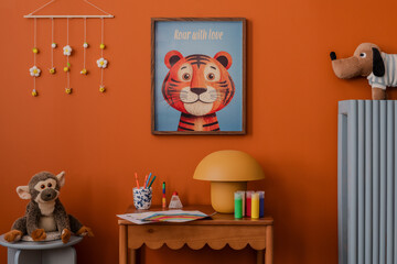 Playful desk setup with kids' drawings, art supplies, and cheerful decor under a framed tiger poster and plush dog toy. Mock up frame.