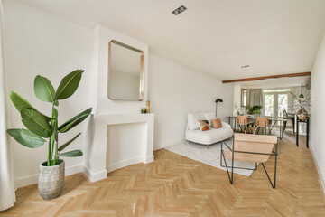 A stylish modern living room featuring wooden flooring, minimalist furniture, and indoor plants, creating a fresh and inviting atmosphere.