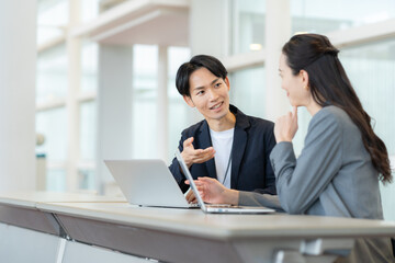 オフィスで会議をする若い男女のエンジニア