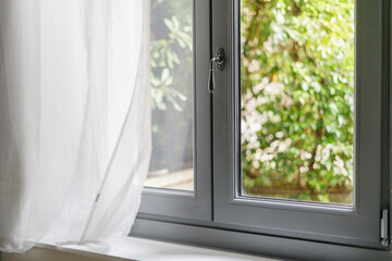 Modern window frame in a bright living room with garden view