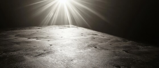 Ethereal light beams illuminate a textured surface creating a dramatic and surreal landscape with a sense of mystery and wonder in monochrome