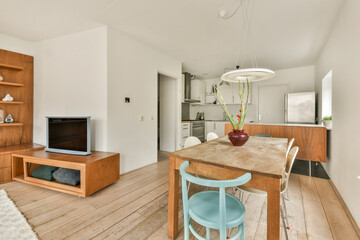 A stylish modern kitchen and dining area featuring minimalist decor, wooden elements, and a cozy atmosphere. Focus on functionality and design elegance.