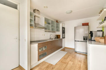 Sleek and stylish modern kitchen features contemporary cabinets, stainless steel appliances, and a cozy layout, perfect for culinary activities.