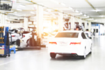 Fototapeta premium Blurry car repair station and repairman working in the garage. Car maintenance or checking of car repair concept.